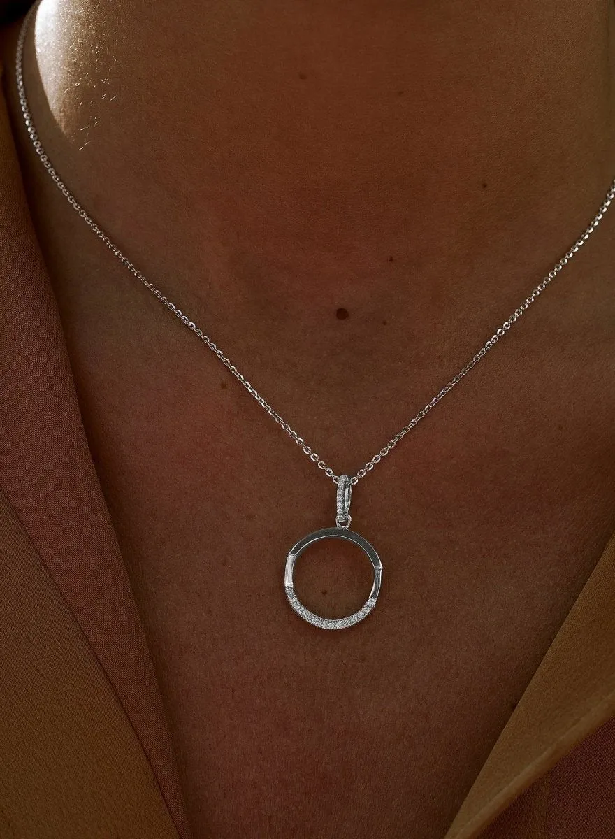 Colgante brillante de plata con diseo geométrico circular desigual y detalle de circonitas