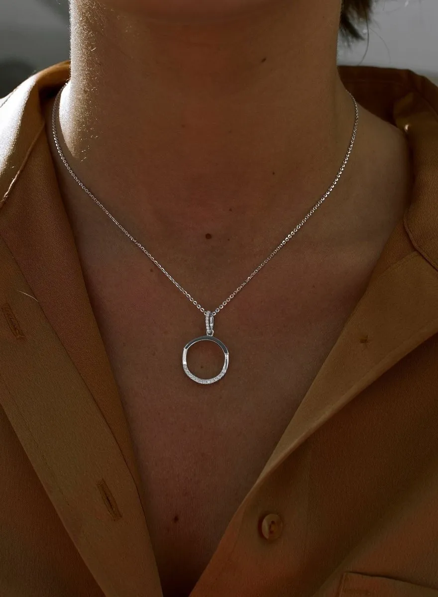 Colgante brillante de plata con diseo geométrico circular desigual y detalle de circonitas